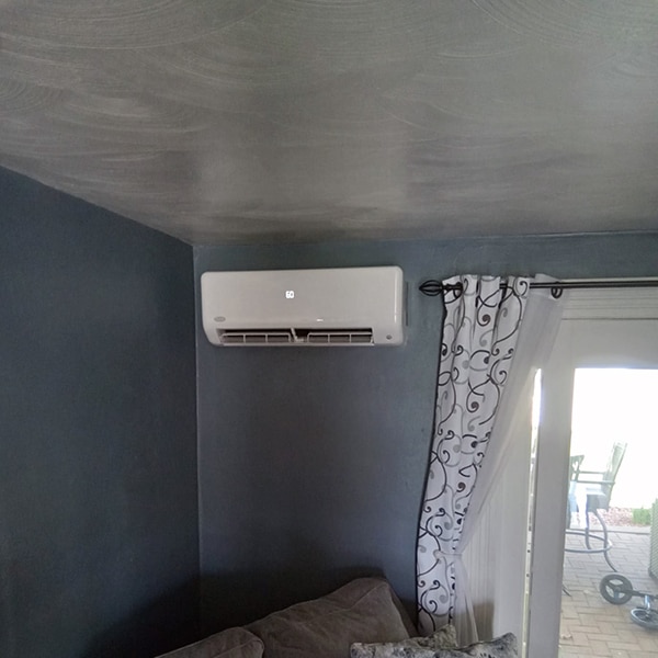 Ductless Mini Split Installation in Johnstown, PA 15904 indoor unit against a blue gray wall in a living room.