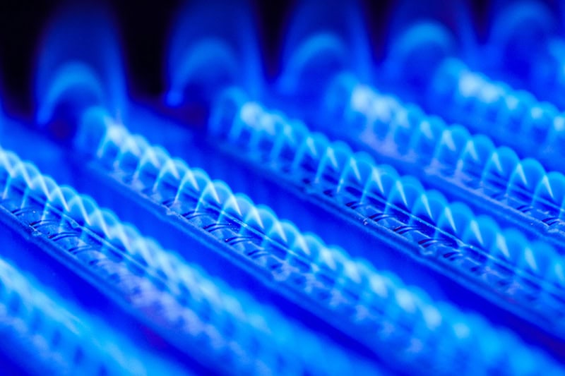 Does Turning the Heat On and Off Save Money? Close up photo of coils inside of a furnace.